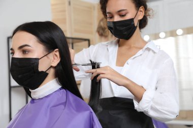 Müşteriyle kuaförde çalışan profesyonel stilist. Coronavirus karantinası sırasında kuaför servisi
