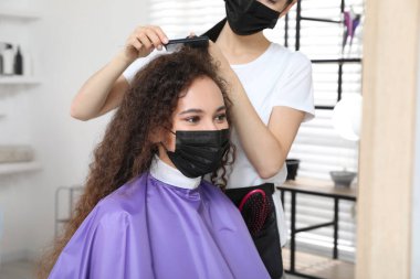 Müşteriyle kuaförde çalışan profesyonel stilist. Coronavirus karantinası sırasında kuaför servisi