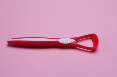 Pembe arka planda bir kırmızı dil temizleyici
