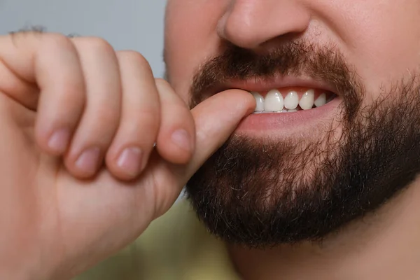 Man Biting His Nails Grey Background Closeup Bad Habit — Zdjęcie stockowe