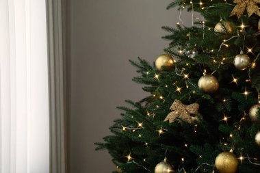 İçinde güzel dekorasyonlar ve tel lambaları olan Noel ağacı, metin için boşluk