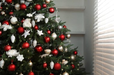 Pencerenin yanındaki güzel dekore edilmiş Noel ağacı.