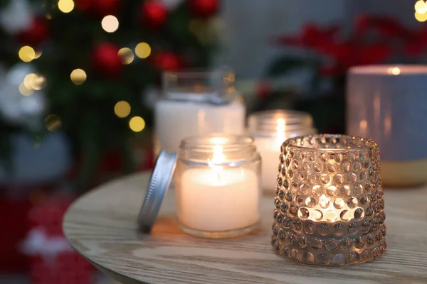 クリスマスのために装飾された部屋で木製のテーブルの上にろうそくを燃やす — ストック写真