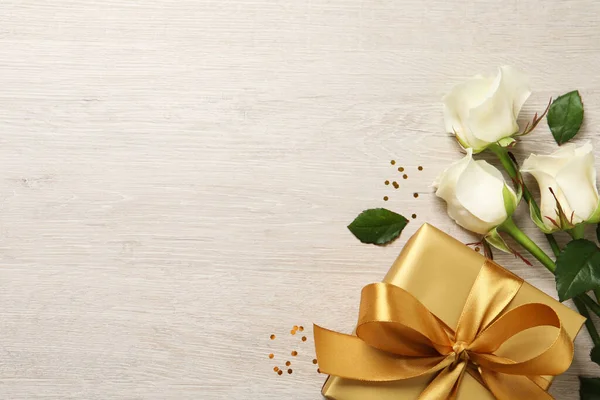 Goldene Geschenkschachtel Und Schöne Rosen Auf Hölzernem Hintergrund Flach Gelegt — Stockfoto