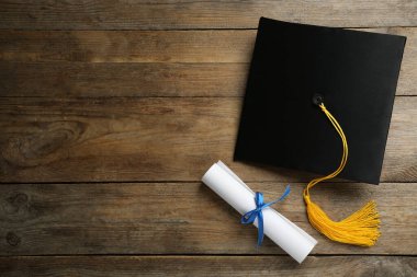 Mezuniyet şapkası ve diploması ahşap masada, düz yatıyordu. Metin için boşluk