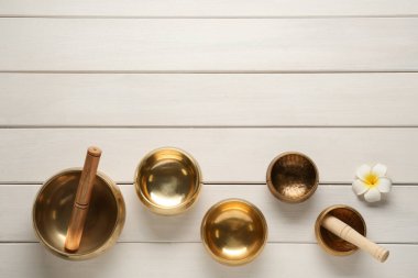 Altın müzik kaseleri, tokmaklar ve beyaz ahşap masa üzerinde çiçek, düz yatıyordu. Metin için boşluk
