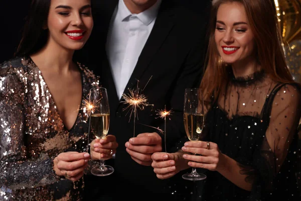 Amigos Felizes Celebrando Ano Novo Contra Fundo Preto Foco Mãos — Fotografia de Stock