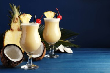 Lezzetli Pina Colada kokteylleri ve mavi ahşap masa malzemeleri, metin için yer