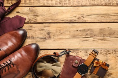 Ayakkabılar, hediye kutusu ve ahşap arka planda farklı erkek aksesuarları, mesaj için yeri olan düz bir yer. Babalar günü kutlaması.