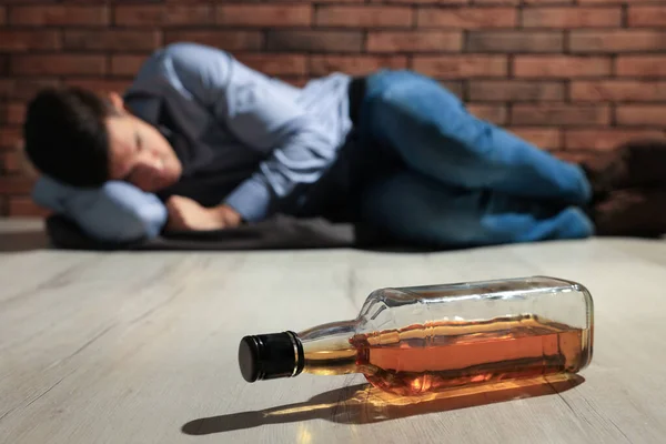 Addicted Man Lying Red Brick Wall Focus Bottle Alcoholic Drink — Stockfoto