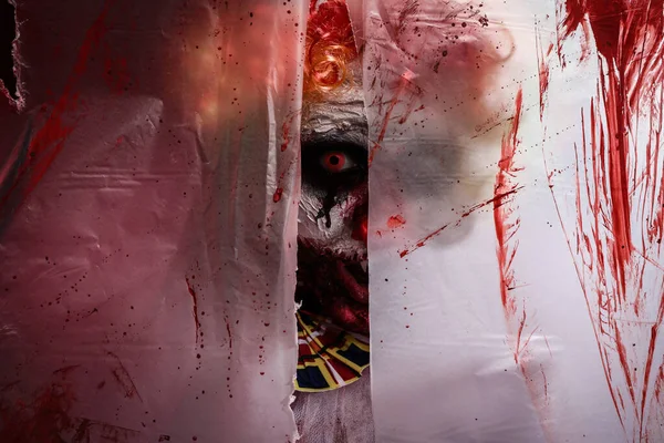 Terrifiant Clown Regardant Travers Trou Dans Film Plastique Teinté Sang — Photo