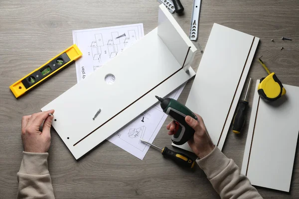 Man Electric Screwdriver Assembling White Furniture Table Top View — Stockfoto