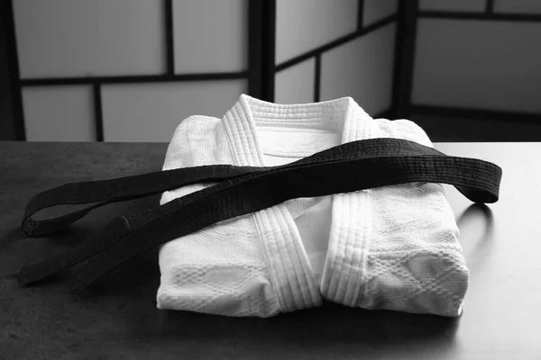 グレーの石のテーブルの上に黒いベルトで統一武道室 — ストック写真