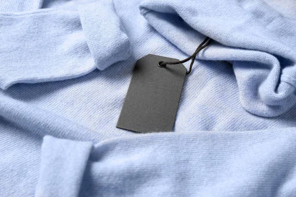 浅蓝色毛衣上的空白灰色标签 案文的篇幅 — 图库照片