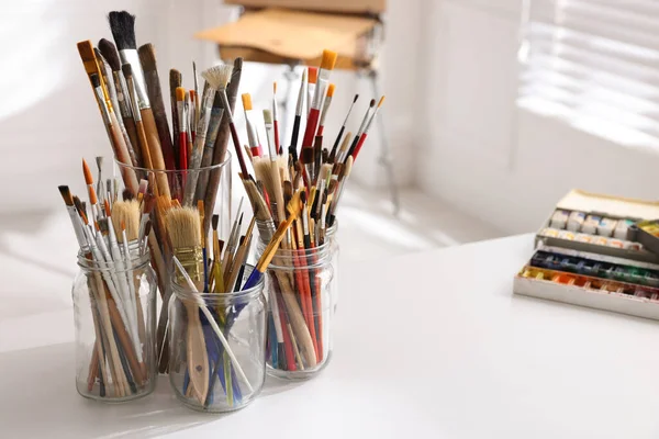 Stüdyoda Beyaz Masada Farklı Fırçalar Boyalar Yazı Için Yer Sanatçının — Stok fotoğraf