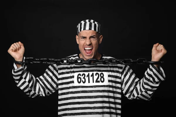 Emotional Prisoner Striped Uniform Trying Break Chain Black Background — Zdjęcie stockowe