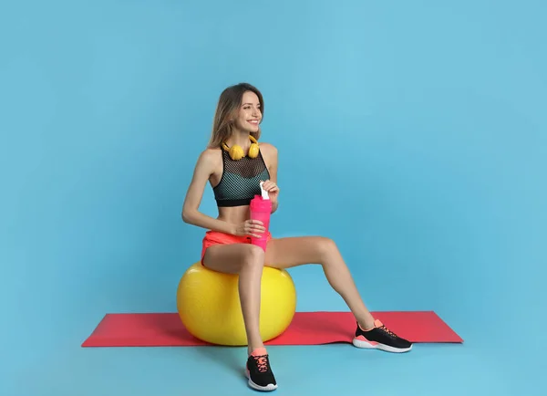 Beautiful Woman Headphones Shaker Sitting Fitness Ball Turquoise Background — стоковое фото