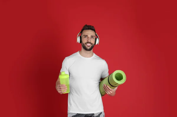 Handsome Man Headphones Yoga Mat Shaker Red Background — 图库照片