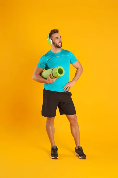 Handsome Man Yoga Mat Headphones Yellow Background — Stockfoto