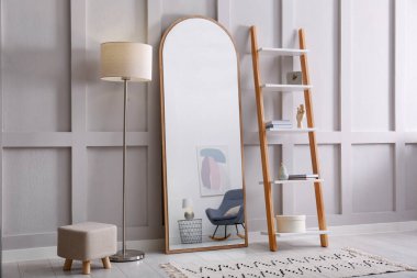 Large mirror near white wall in light room