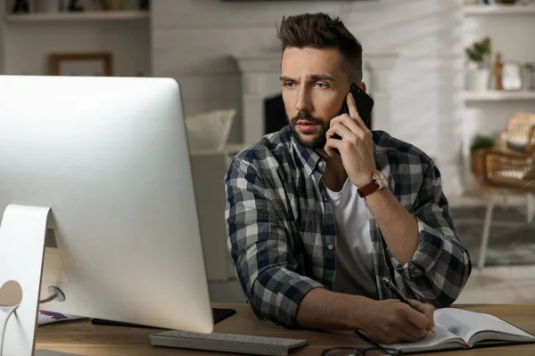 Ofisteki Masada Bilgisayarla Çalışan Bir Adam Telefonla Konuşuyor — Stok fotoğraf