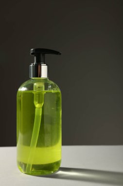 Bottle of liquid soap on grey table. Space for text