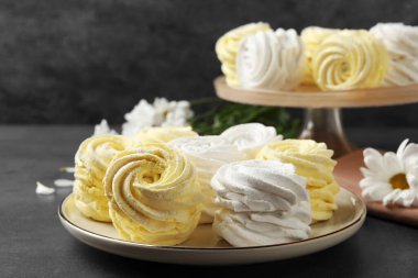 Plate with delicious zephyrs on grey table. Space for text