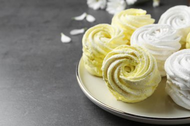 Plate with delicious zephyrs on grey table. Space for text