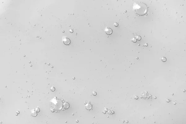 Hydrophilic oil with bubbles on white background, top view