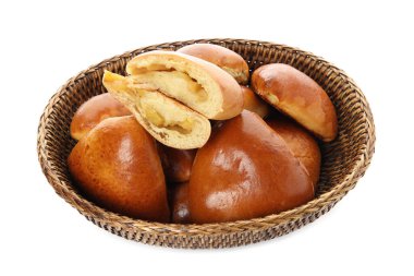 Delicious baked apple pirozhki in wicker basket on white background