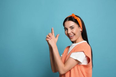 Açık mavi arka planda şık bandana takan genç kadın, metin için boşluk