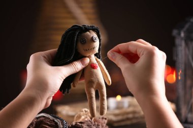 Kadın vudu bebeğinin kalbine iğne batıran kadın.