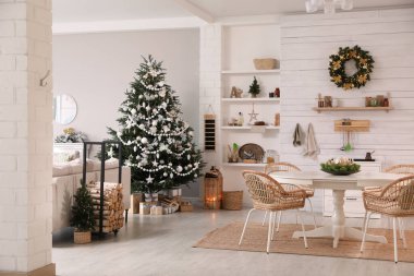 Noel ağacı ve şenlikli dekoru olan samimi bir yemek odası.