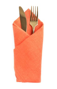 Golden fork and knife wrapped in orange napkin on white background, top view