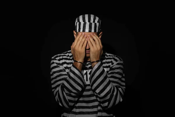 Remorseful Prisoner Striped Uniform Handcuffs Hiding His Face Black Background — Fotografia de Stock