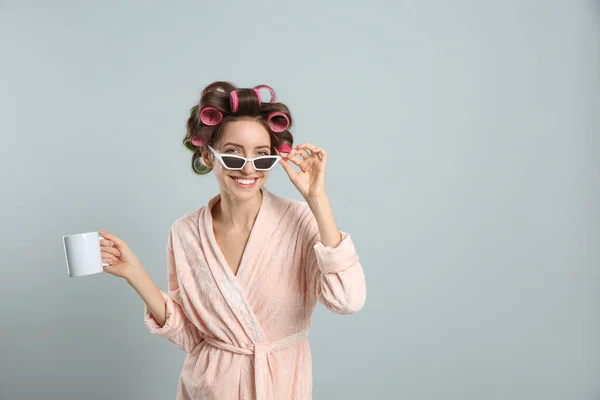 Beautiful Young Woman Bathrobe Hair Curlers Holding Cup Drink Light — стоковое фото