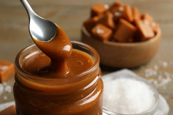 Taking Yummy Salted Caramel Spoon Glass Jar Table Closeup Space — Stock Photo, Image