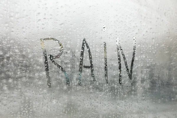 Word Rain Written Foggy Window Closeup View — Stockfoto