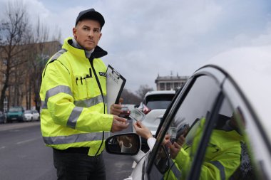 Kadın, arabanın camından polise rüşvet veriyor.