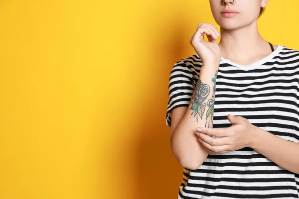 Γυναίκα Που Βάζει Κρέμα Στο Χέρι Της Τατουάζ Κίτρινο Φόντο — Φωτογραφία Αρχείου