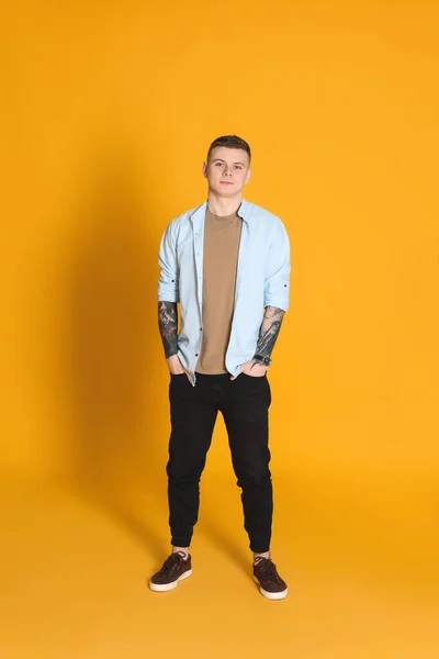 Young Man Tattoos Yellow Background — Stockfoto