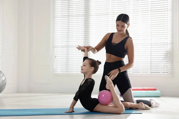 Gymnastic Coach Helping Little Girl Exercise Ball Indoors — Photo