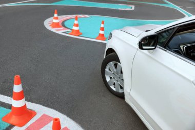 Modern car on test track with traffic cones, above view. Driving school