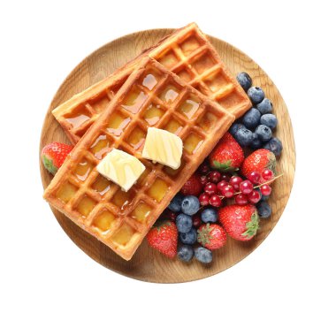 Plate of delicious Belgian waffles with honey, berries and butter isolated on white, top view