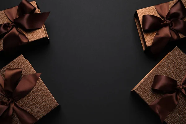 Brown Gift Boxes Decorated Satin Bows Black Background Flat Lay — Stockfoto