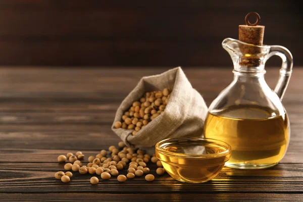 Stock image Composition with soybean oil on wooden table, space for text