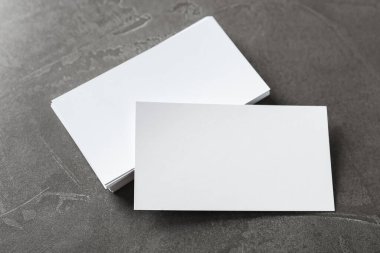 Gri masanın üstünde boş kartvizitler var. Tasarım için model