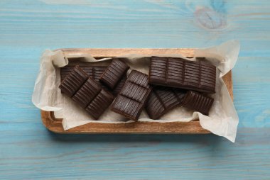Tray with delicious hematogen on blue wooden table, top view