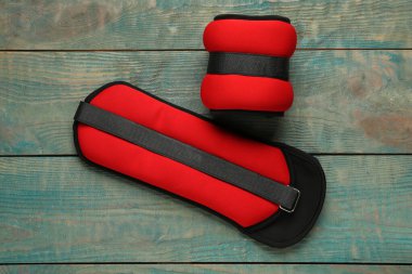 Red weighting agents on light blue wooden table, flat lay