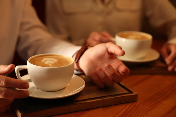 木製のテーブルで香り高いコーヒーを飲みながらカップル クローズアップ — ストック写真